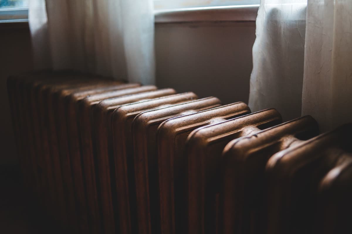 Sunlight falling across a cast iron radiator in a home