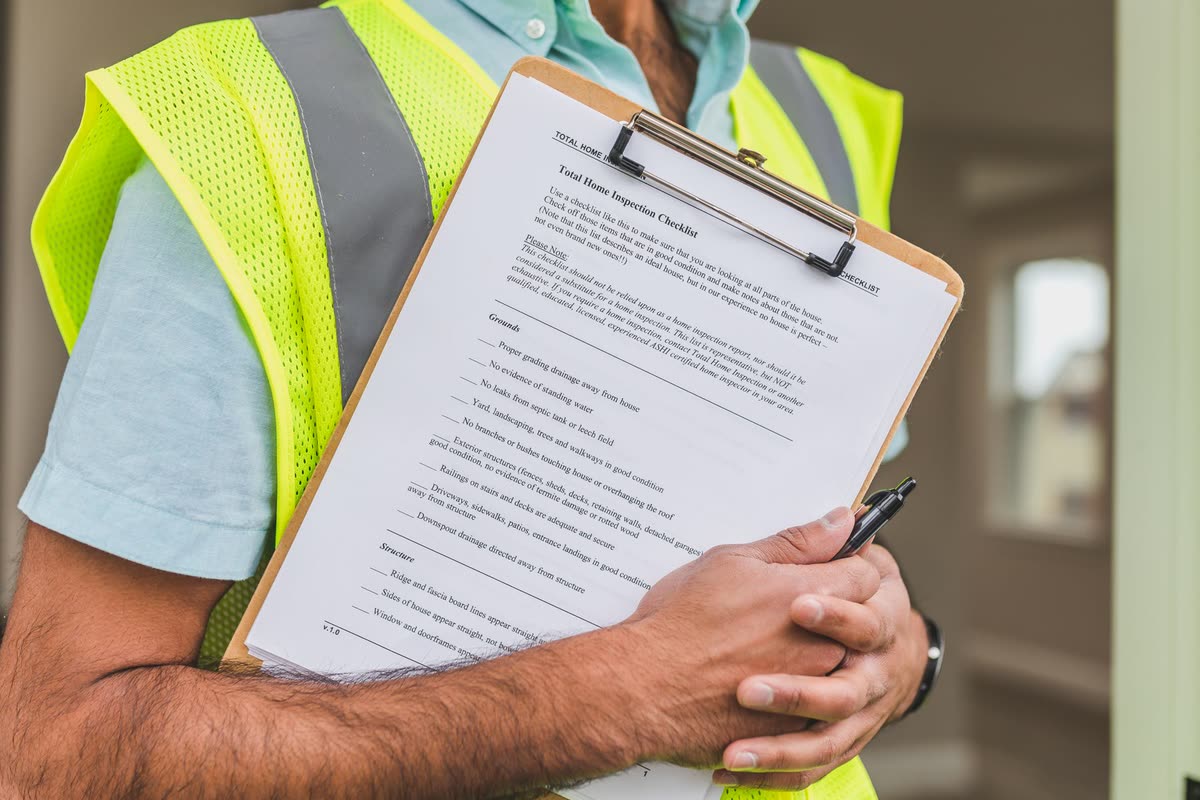 An assessor working through a property survey checklist on a clipboard